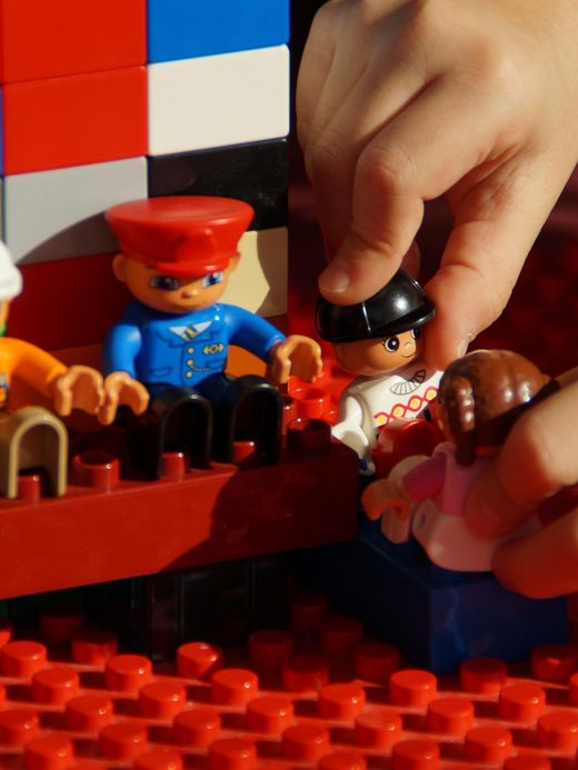 Le mani di un bambino che giocano con i mattoncini colorati